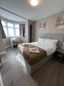 ein Schlafzimmer mit einem großen Bett, auf dem zwei Handtücher liegen in der Unterkunft Rest Inn Edmonton in Edmonton