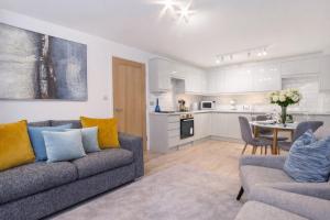 a living room with two couches and a kitchen at Minster's Reach Apartments -Stylish City-Centre Retreat's in York
