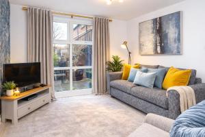 a living room with a couch and a tv at Minster's Reach Apartments -Stylish City-Centre Retreat's in York