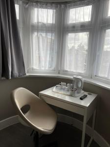 Ein weißer Schreibtisch mit einem Stuhl neben einem Fenster in der Unterkunft Rest Inn Edmonton in Edmonton