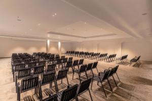 an empty room with rows of chairs in it at Avisa Hotel & Resort Abu Road - Luxury Pool & Mountain View in Ābu Road +27 photos