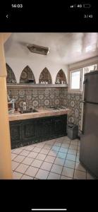 a kitchen with a sink and a window and a refrigerator at Riad Four Rooms & Pool in Marrakesh