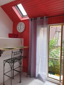 a room with a clock and a table and a window at Studio gare et commerces sur place in Nogent-lʼArtaud