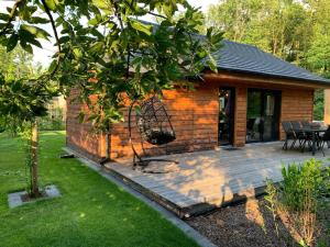 a cabin with a wooden deck in a yard at Chalet Liquidambar in Zutendaal