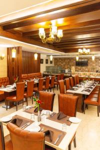 a restaurant with tables and chairs in a room at The Grand Ambassador in Phagwāra