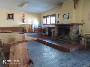 a living room with a stone fireplace and a table at Sogni di Montagna -Campitello Matese in San Massimo