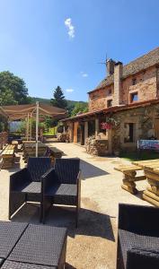 a patio with chairs and tables and a building at Chambres d'hôtes Les Violles in Chirac