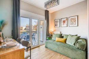 a living room with a green couch and a table at Modern City Studio with Balcony Columbus Apartment in Chios +30 photos
