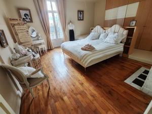a bedroom with a white bed and a wooden floor at Chez Madame in Dijon