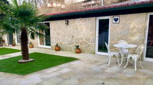a patio with a table and chairs and a palm tree at Casa da Penalva in Santa Cruz do Lima