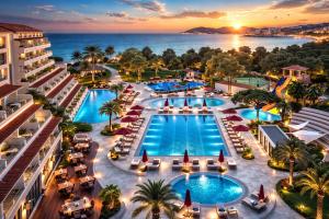an aerial view of a resort with a pool and the ocean at Batıhan Beach Resort & Spa in Kuşadası