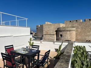 a table and chairs on the roof of a castle at Seafront Apartments in Monopoli Old Town in Monopoli +21 photos