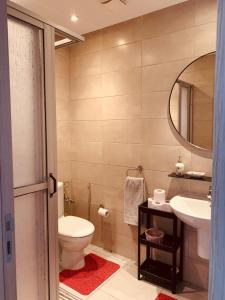 a bathroom with a toilet and a sink and a mirror at Costa Mar, Costa 2 in Martil +14 photos