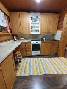 a kitchen with wooden cabinets and a stove top oven at Artunpirtti in Keuruu