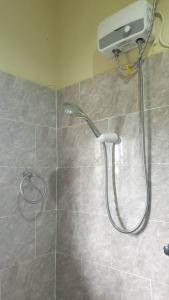a shower with a shower head in a bathroom at Grace View Villa in Trofwi +3 photos