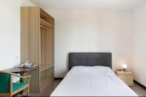 a bedroom with a bed and a desk and a chair at La Terrazza Guest House in San Zeno