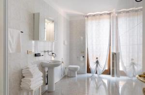 a white bathroom with a sink and a toilet at La Terrazza Guest House in San Zeno +39 photos