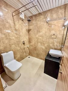 a bathroom with a toilet and a glass shower at Krimzon Manor in Srinagar