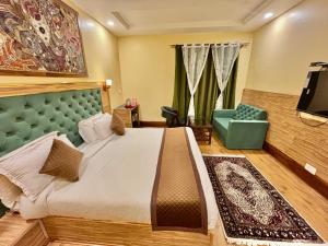 a bedroom with a bed and a couch and a television at Krimzon Manor in Srinagar