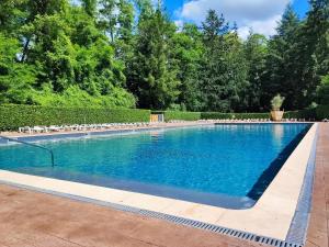 a swimming pool with blue water in a yard at Tiny Sweet Home - 3 nuits minimum in Saint-Chéron +34 photos