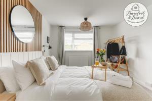 a bedroom with a white bed and a mirror at Luxury 2-Bed House in Stevenage Sleeps 6 Free Parking Barefoot & Board in Shephall