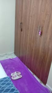 a pair of slippers sitting on a purple rug next to a door at KiQao in Nakuru +3 photos