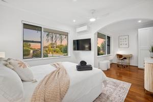 a white bedroom with a large bed and windows at Beach House Family Friendly Enclosed Yard in Rockingham