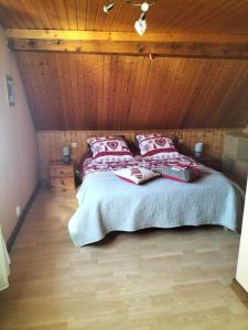 a bedroom with a bed with a wooden ceiling at Chalet La Grange de Madi in Muhlbach-sur-Munster