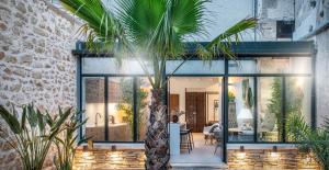 a house with glass doors and a palm tree at JK Moulin Paradou in Paradou