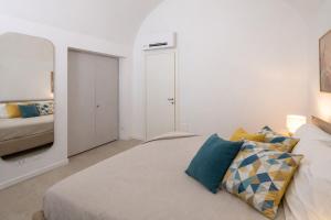a white bedroom with a bed and a mirror at Erbusco Charme Apartment in Erbusco