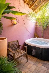 a bathtub with a chair and a wooden chair at L'Apothéose in Saint-Jean-les-Deux-Jumeaux