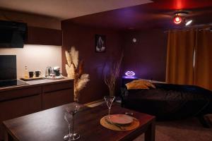 a living room with a bed and a table with wine glasses at L'Apothéose in Saint-Jean-les-Deux-Jumeaux +9 photos