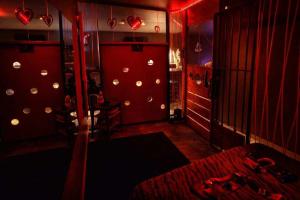 a red room with a bed and a wall with lights at L'Apothéose in Saint-Jean-les-Deux-Jumeaux