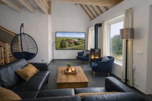 a living room with a couch and a table at Ballumerhoeve Finn lodge in Ballum