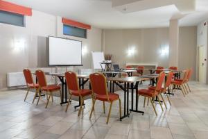 a conference room with tables and chairs and a screen at Hotel Borgo Di Cortefreda - Place of Charme in Tavarnelle Val di Pesa +124 photos