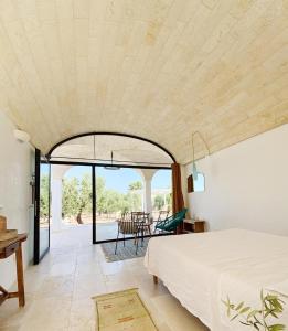 a bedroom with a bed and a view of a table at Trulli Paradise Ostuni - Villa Privata con Piscina in Ostuni