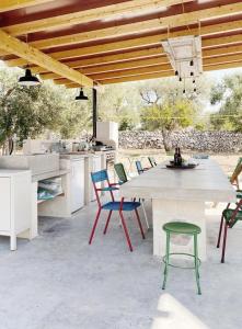 a patio with a table and chairs and a kitchen at Trulli Paradise Ostuni - Villa Privata con Piscina in Ostuni