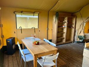 a dining room with a table and chairs in a tent at Camping De Boerinn in Kamerik