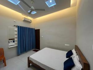 a bedroom with a bed and a ceiling fan at Chaithanya Residency Near to IIM & NIT Kozhikode in Kunnamangalam