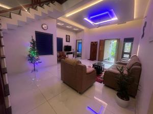 a living room with two couches and a christmas tree at Chaithanya Residency Near to IIM & NIT Kozhikode in Kunnamangalam