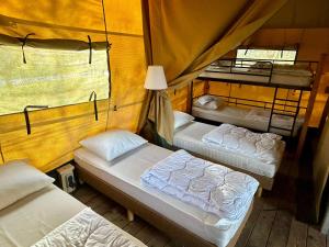 a group of three beds in a room at Camping De Boerinn in Kamerik