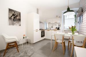 a kitchen with white cabinets and a table and chairs at Casa Strehler in Trieste