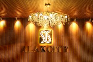 a chandelier in a room with a sign on a wall at Hotel Alak City in Vallakottai