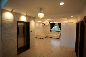 a living room with a couch and a chandelier at Hotel Alak City in Vallakottai