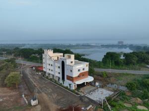 an aerial view of a building with a river at Hotel Alak City in Vallakottai