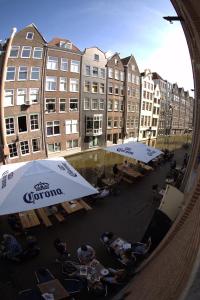 a group of tables and umbrellas in front of buildings at Hotel The Globe in Amsterdam