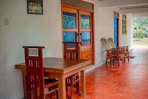 a dining room with a wooden table and chairs at Tourist Holiday Inn in Dambulla