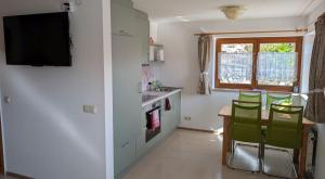 a kitchen with a table and chairs and a television at FeWo im Grünen in Häusern