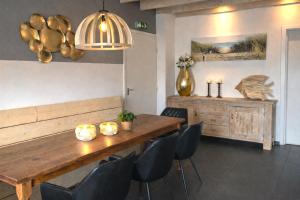 a dining room with a wooden table and chairs at Ballumerhoeve Finn lodge in Ballum