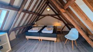 a bedroom with a bed and a blue chair at Ballumerhoeve Finn lodge in Ballum